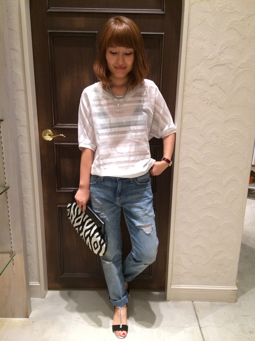 ホワイト系のシャツ/ブラウス、ブラック系のクラッチバッグを着用したレディースの春コーディネートの1枚目の写真