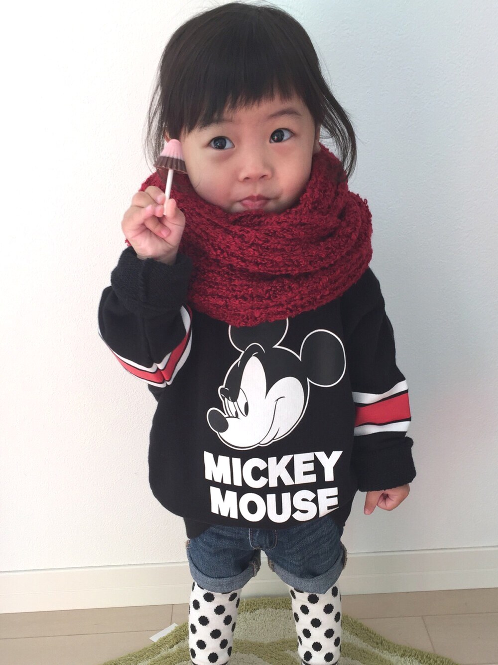 ブラック系のスウェット、ブルー系のデニムパンツ、レッド系のストール/ショールを着用したキッズの冬コーディネートの1枚目の写真