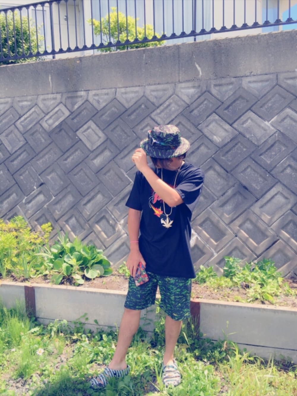 ブラック系のTシャツ/カットソー、グリーン系のその他パンツ、ホワイト系のサンダルを着用したメンズの夏コーディネートの1枚目の写真