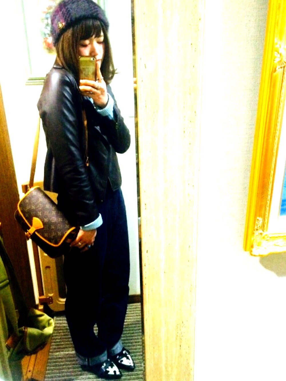 ブラック系のパンプス、ブルー系のデニムパンツ、ブラウン系のライダースジャケットを着用したレディースの冬コーディネートの1枚目の写真