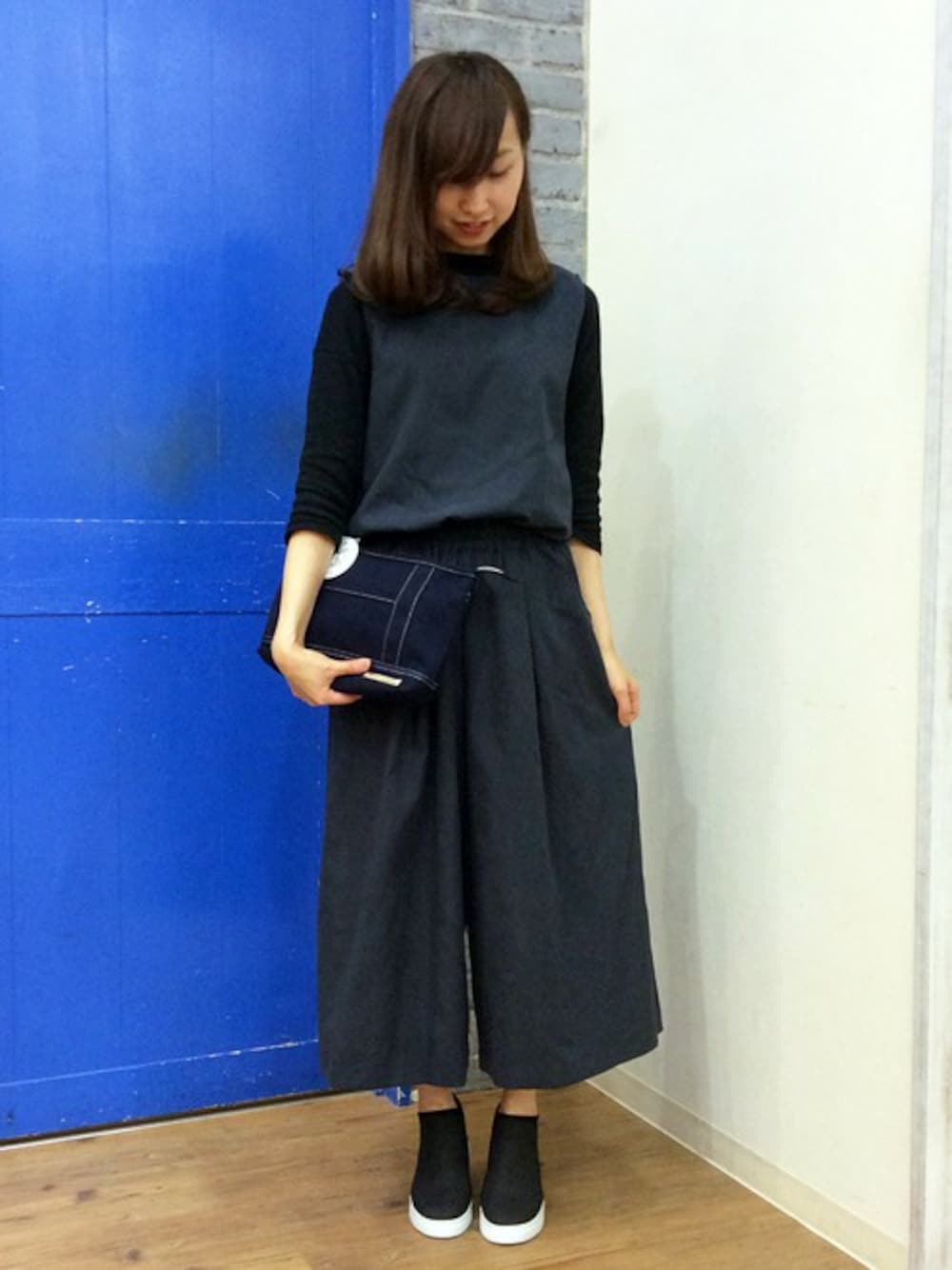 ブルー系のサロペット/オーバーオール、ブルー系のショルダーバッグ、ブラック系のTシャツ/カットソーを着用したレディースの秋コーディネートの1枚目の写真