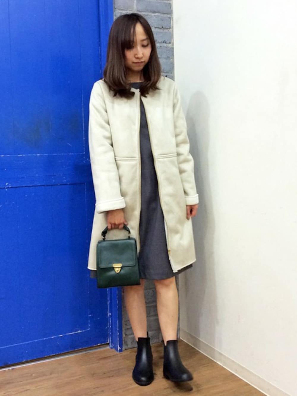 グレー系のワンピース、ホワイト系のムートンコート、ブラック系のレインシューズを着用したレディースの秋コーディネートの1枚目の写真