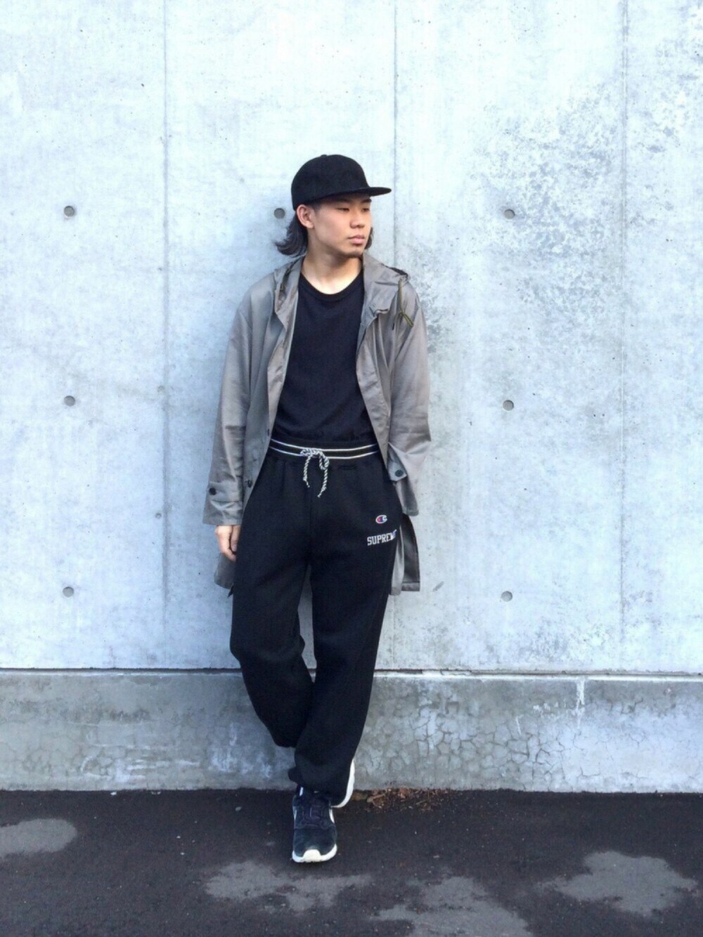 グリーン系のチェスターコート、ブラック系のTシャツ/カットソー、ブラック系のパンツを着用したメンズの秋コーディネートの1枚目の写真