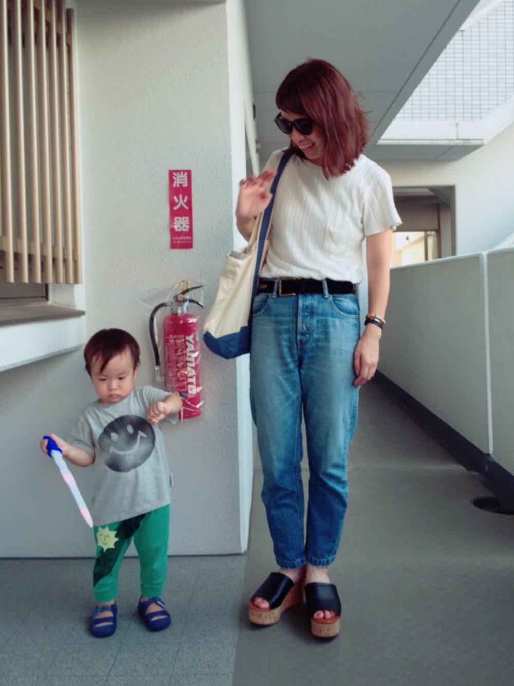 ホワイト系のTシャツ/カットソー、ホワイト系のトートバッグ、ブルー系のデニムパンツを着用したレディースの夏コーディネートの1枚目の写真