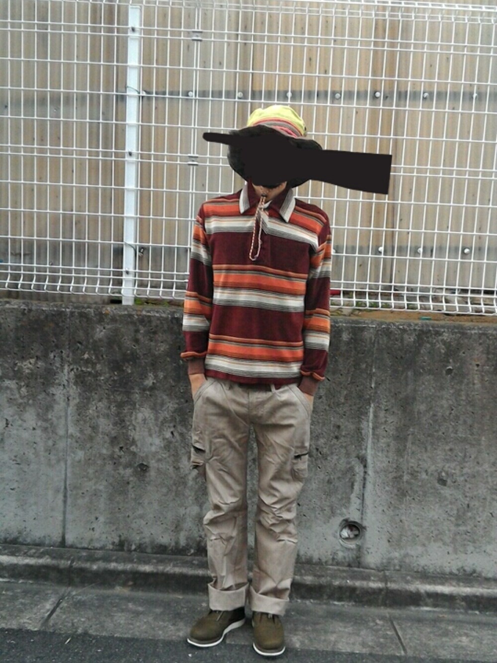 ベージュ系のカーゴパンツ、ブラウン系のポロシャツ、グリーン系のシューズを着用したメンズの秋コーディネートの1枚目の写真