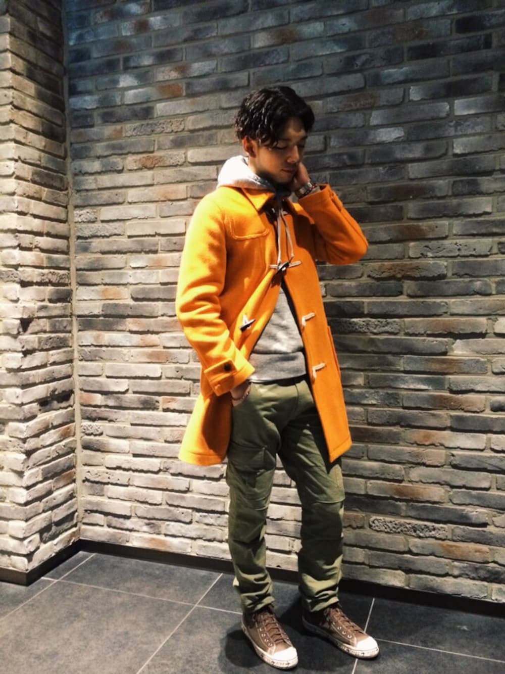 ブラウン系のスニーカー、オレンジ系のダッフルコートを着用したメンズの冬コーディネートの1枚目の写真