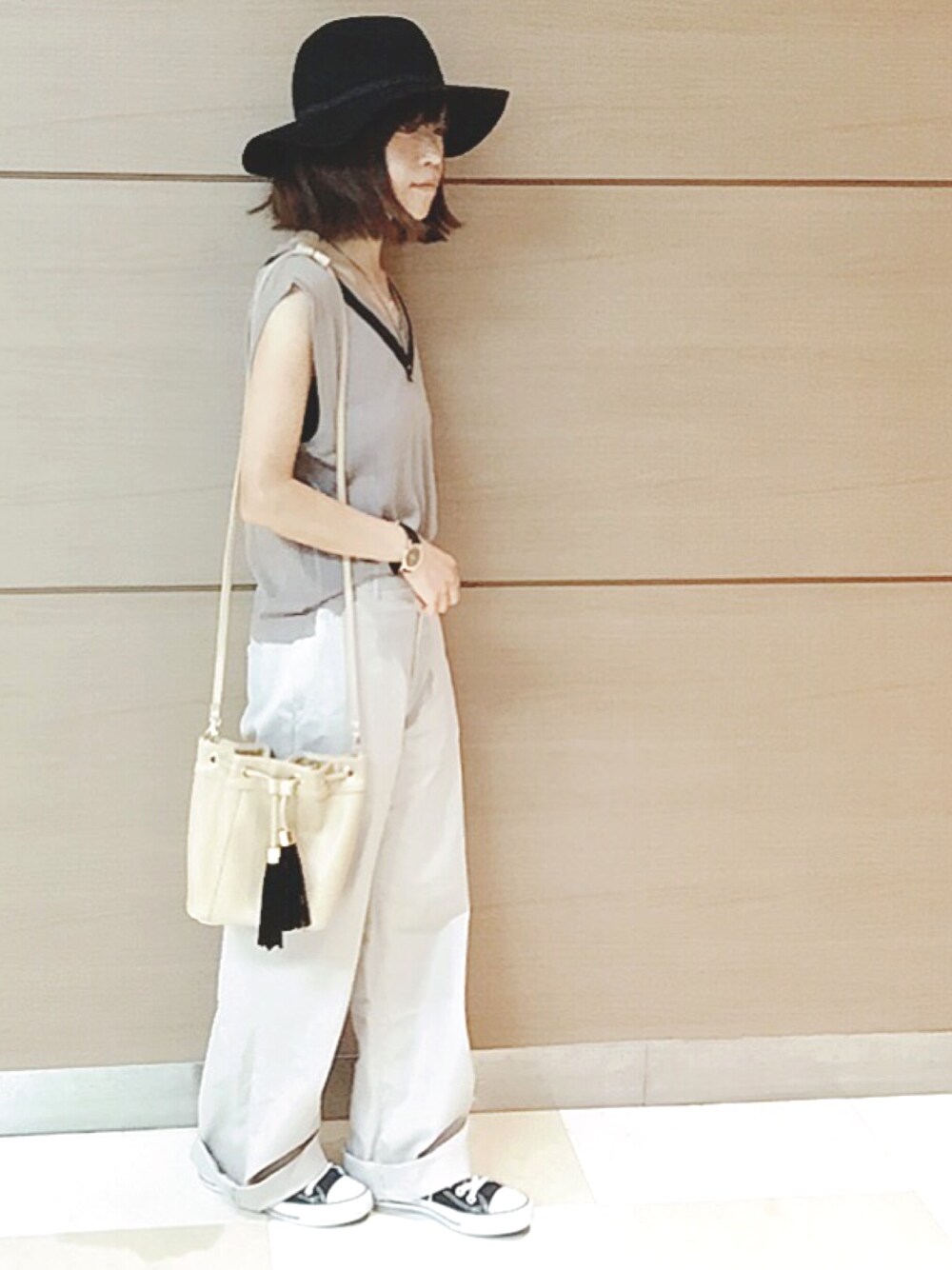 ベージュ系のベスト、ベージュ系のショルダーバッグ、ブラック系のスニーカーを着用したレディースの秋コーディネートの1枚目の写真