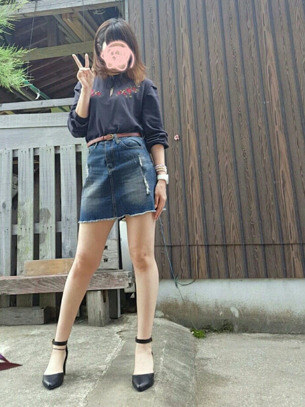 ブラック系のパンプス、ブラック系のスウェット、ブルー系のデニムスカートを着用したレディースの秋コーディネートの1枚目の写真