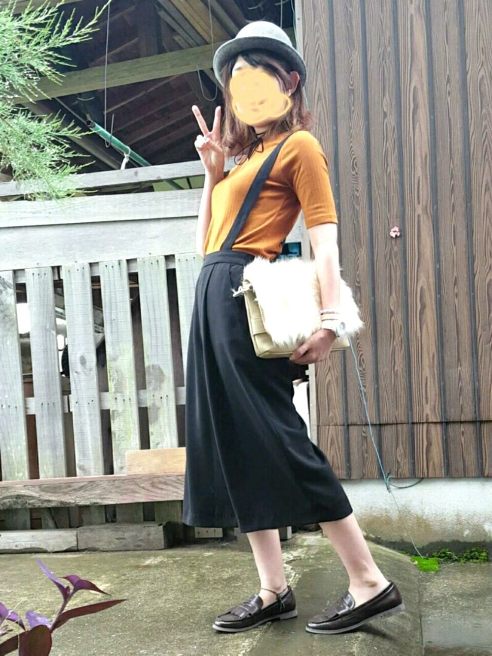 ブラウン系のローファー、オレンジ系のトップス、ベージュ系のショルダーバッグを着用したレディースの秋コーディネートの1枚目の写真