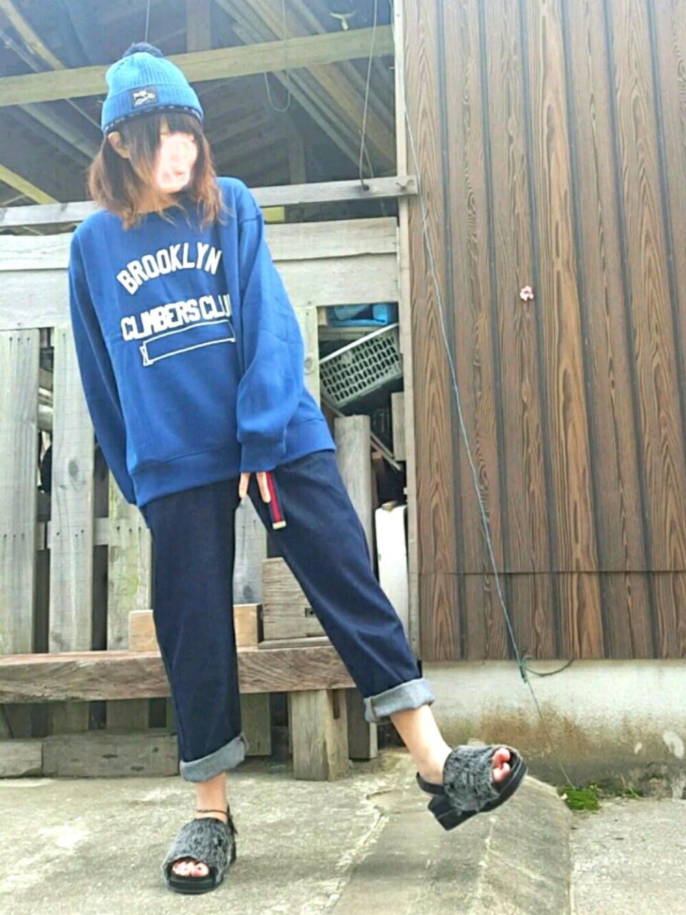 グレー系のシューズ、ブルー系のスウェット、ブルー系のデニムパンツを着用したレディースの秋コーディネートの1枚目の写真