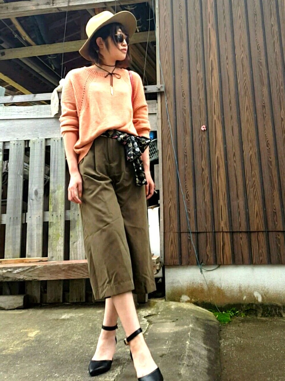 ブラウン系のその他パンツ、レッド系のショルダーバッグ、ピンク系のニット/セーターを着用したレディースの秋コーディネートの1枚目の写真