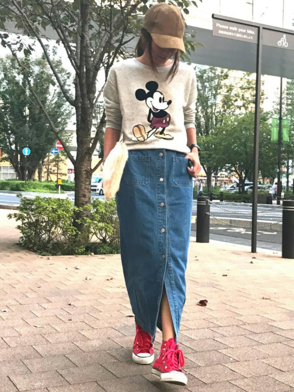 グレー系のスウェット、その他のデニムスカート、レッド系のスニーカーを着用したレディースの秋コーディネートの1枚目の写真