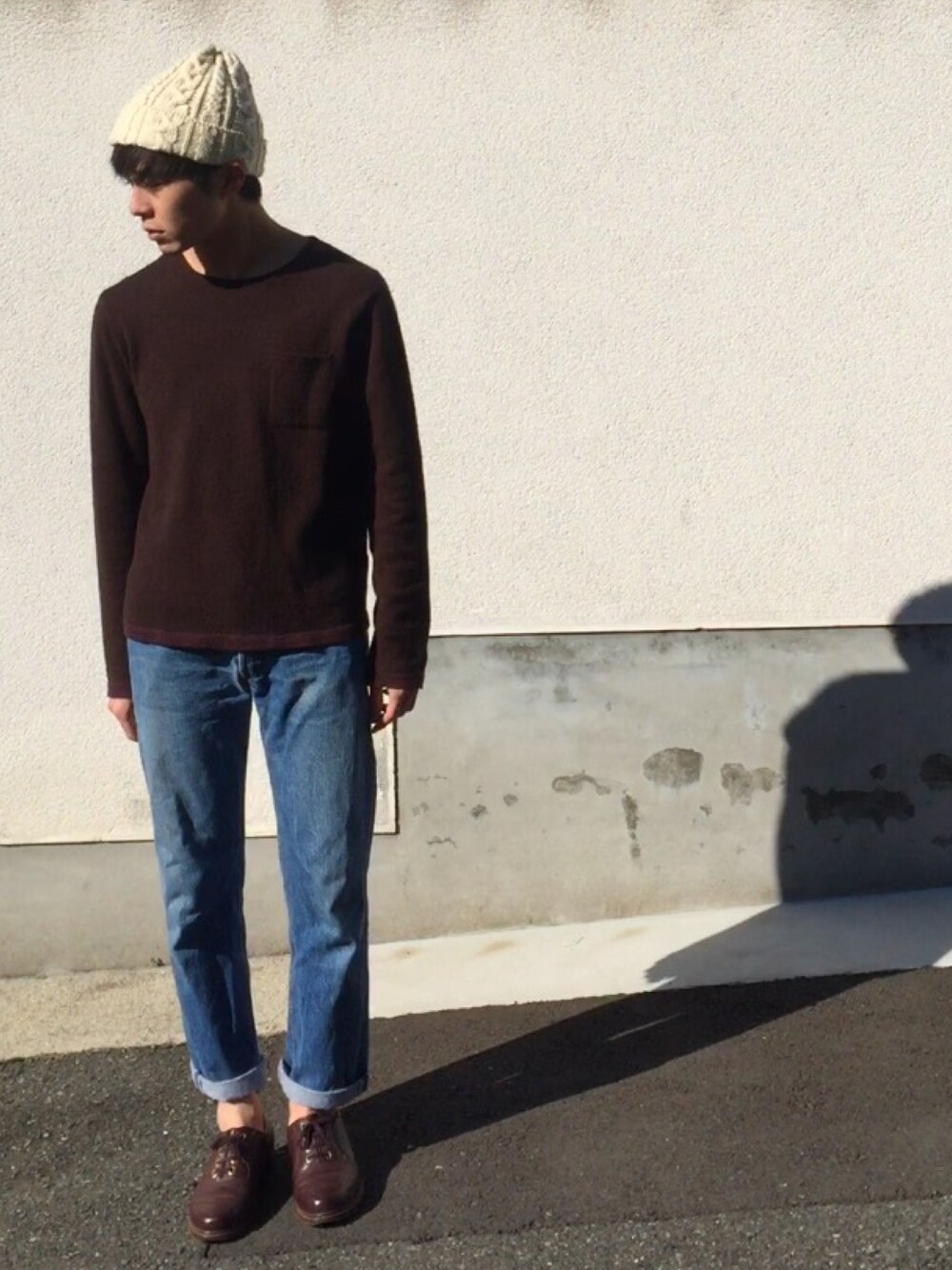 ブラウン系のニット/セーター、ブルー系のデニムパンツ、ブラウン系のブーツを着用したメンズの冬コーディネートの1枚目の写真