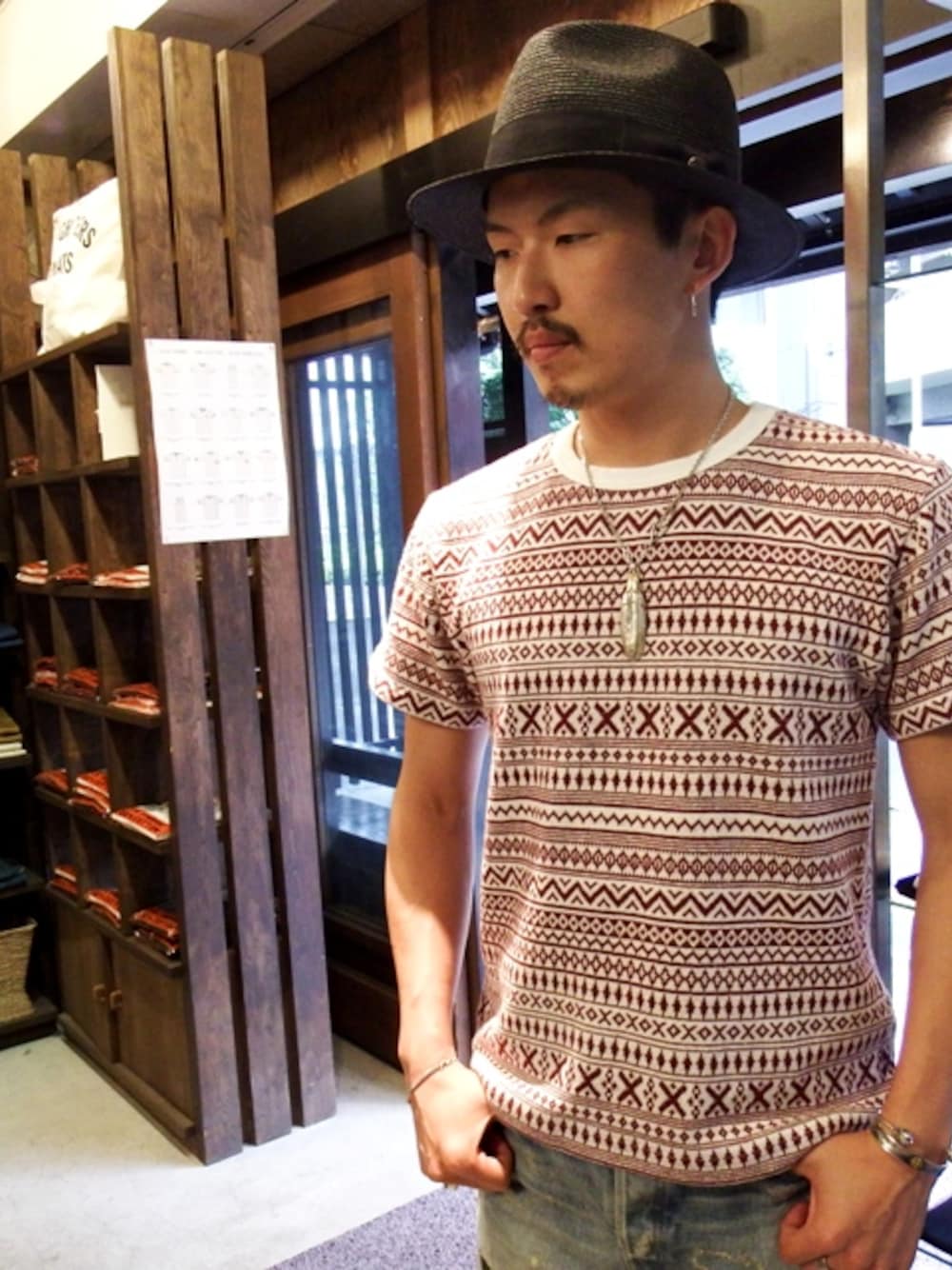 レッド系のTシャツ/カットソー、ブラック系のハットを着用したメンズの夏コーディネートの1枚目の写真