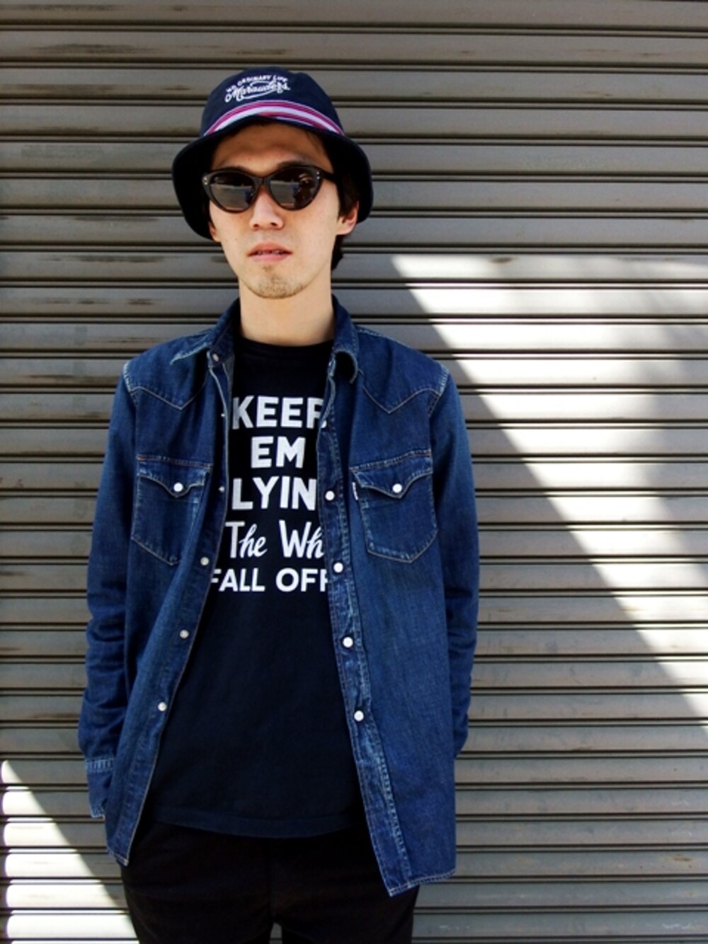 ブルー系のシャツ/ブラウス、ブラック系のTシャツ/カットソー、ブラック系のハットを着用したメンズの春コーディネートの1枚目の写真