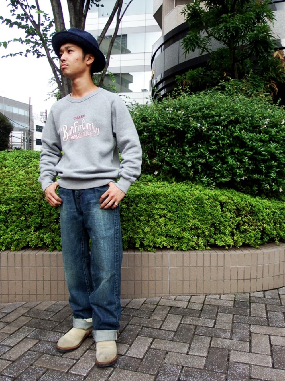 グレー系のスウェット、ブルー系のデニムパンツ、ブルー系のハットを着用したメンズの秋コーディネートの1枚目の写真