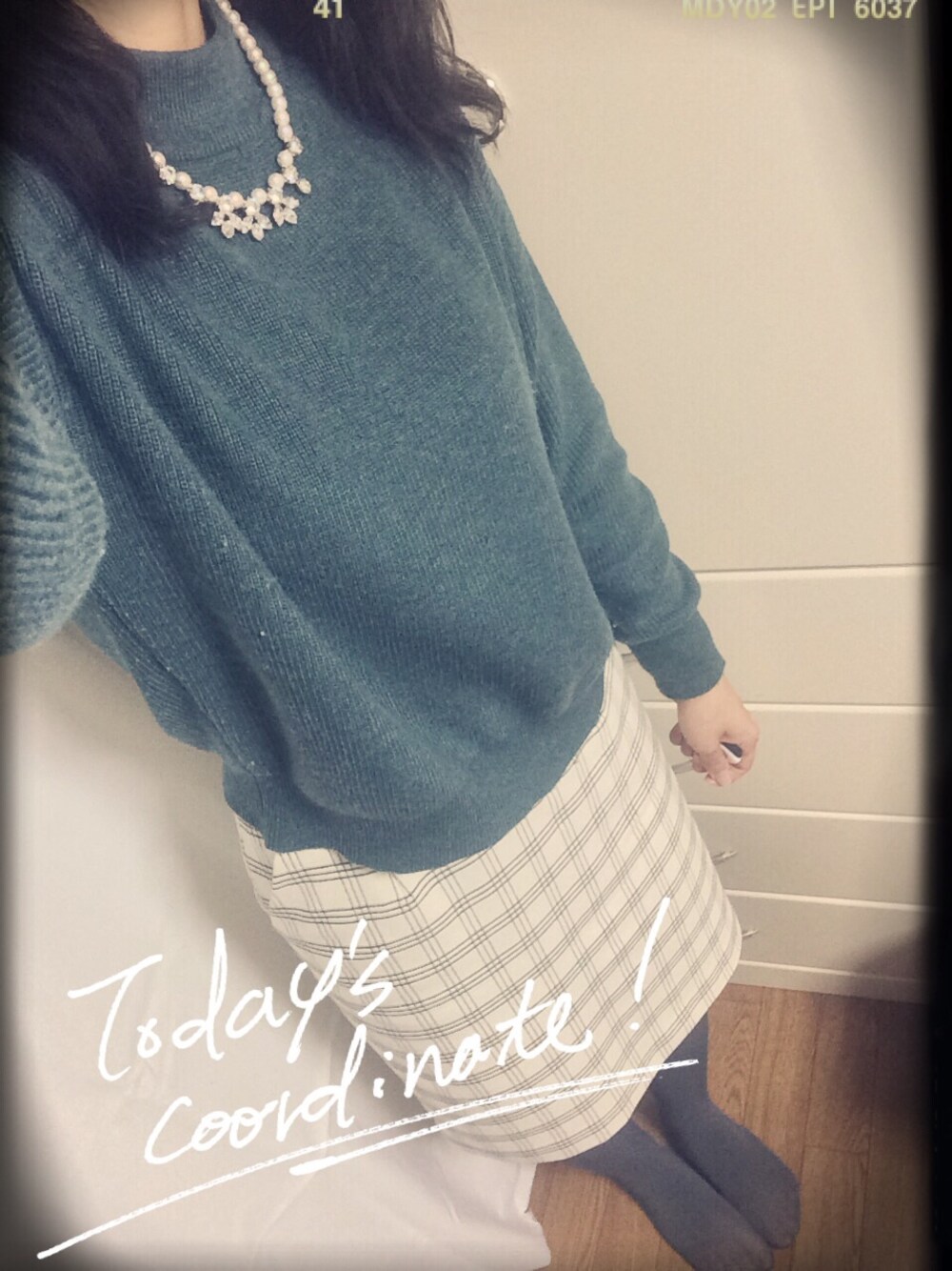 ホワイト系のスカート、グリーン系のニット/セーター、ホワイト系のネックレスを着用したレディースの冬コーディネートの1枚目の写真