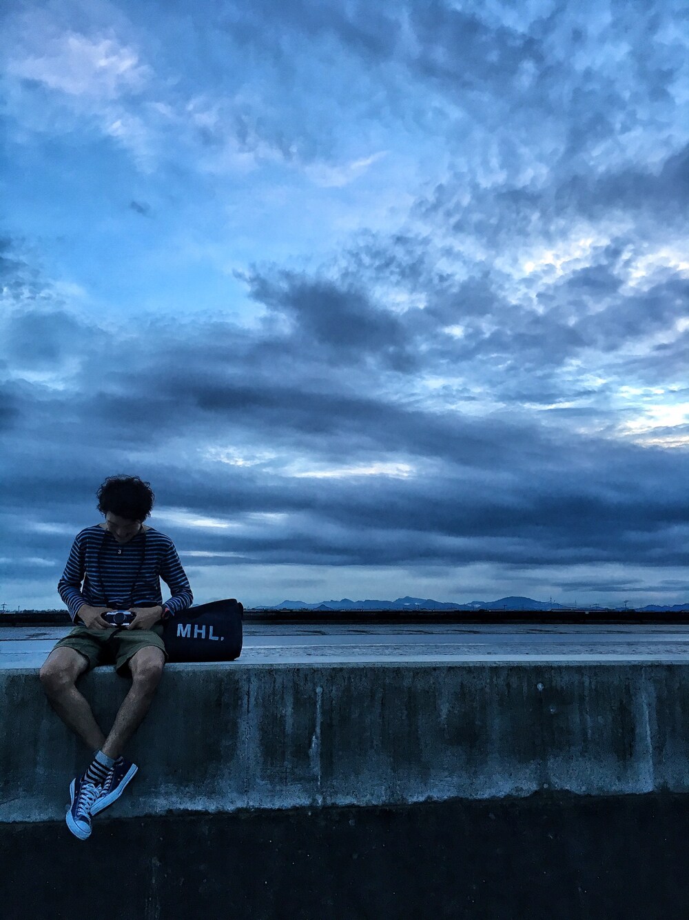 ブルー系のスニーカー、グリーン系のその他パンツ、ブラック系のバッグを着用したメンズの秋コーディネートの1枚目の写真