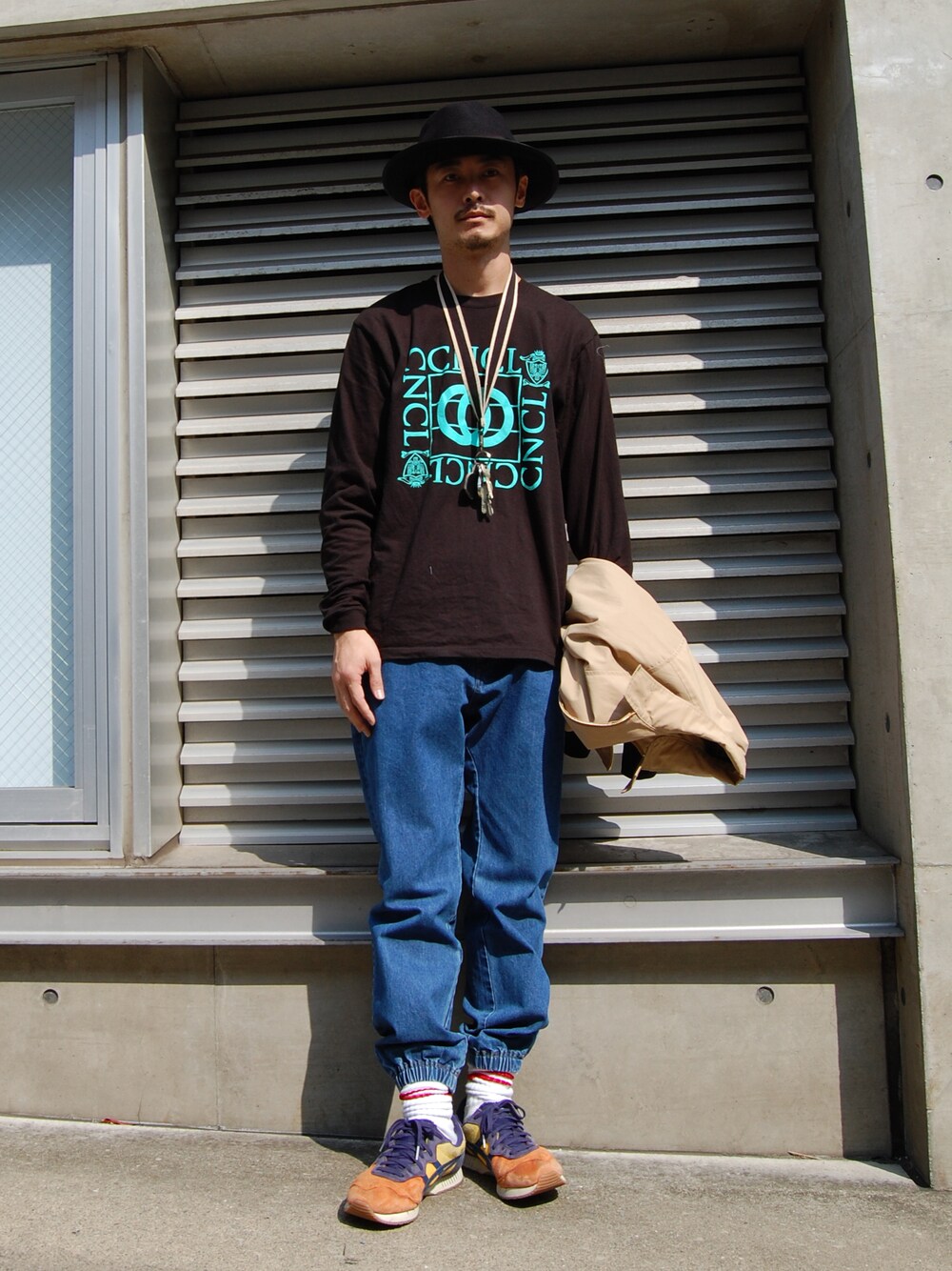 ブルー系のデニムパンツ、ブラウン系のハットを着用したメンズの秋コーディネートの1枚目の写真