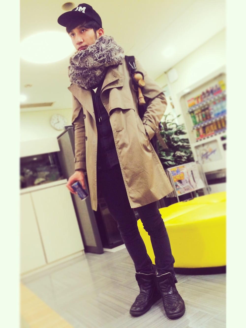 ベージュ系のトレンチコート、ブラック系のスニーカー、グレー系のデニムパンツを着用したメンズの冬コーディネートの1枚目の写真