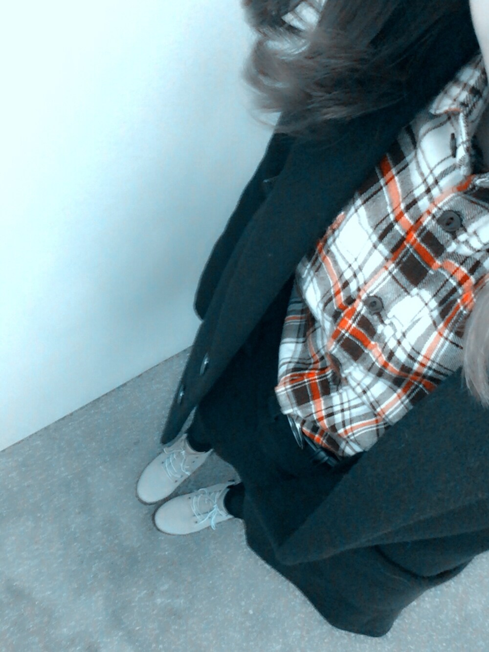 ブラック系のチェスターコート、レッド系のシャツ/ブラウス、オレンジ系のシューズを着用したレディースの冬コーディネートの1枚目の写真