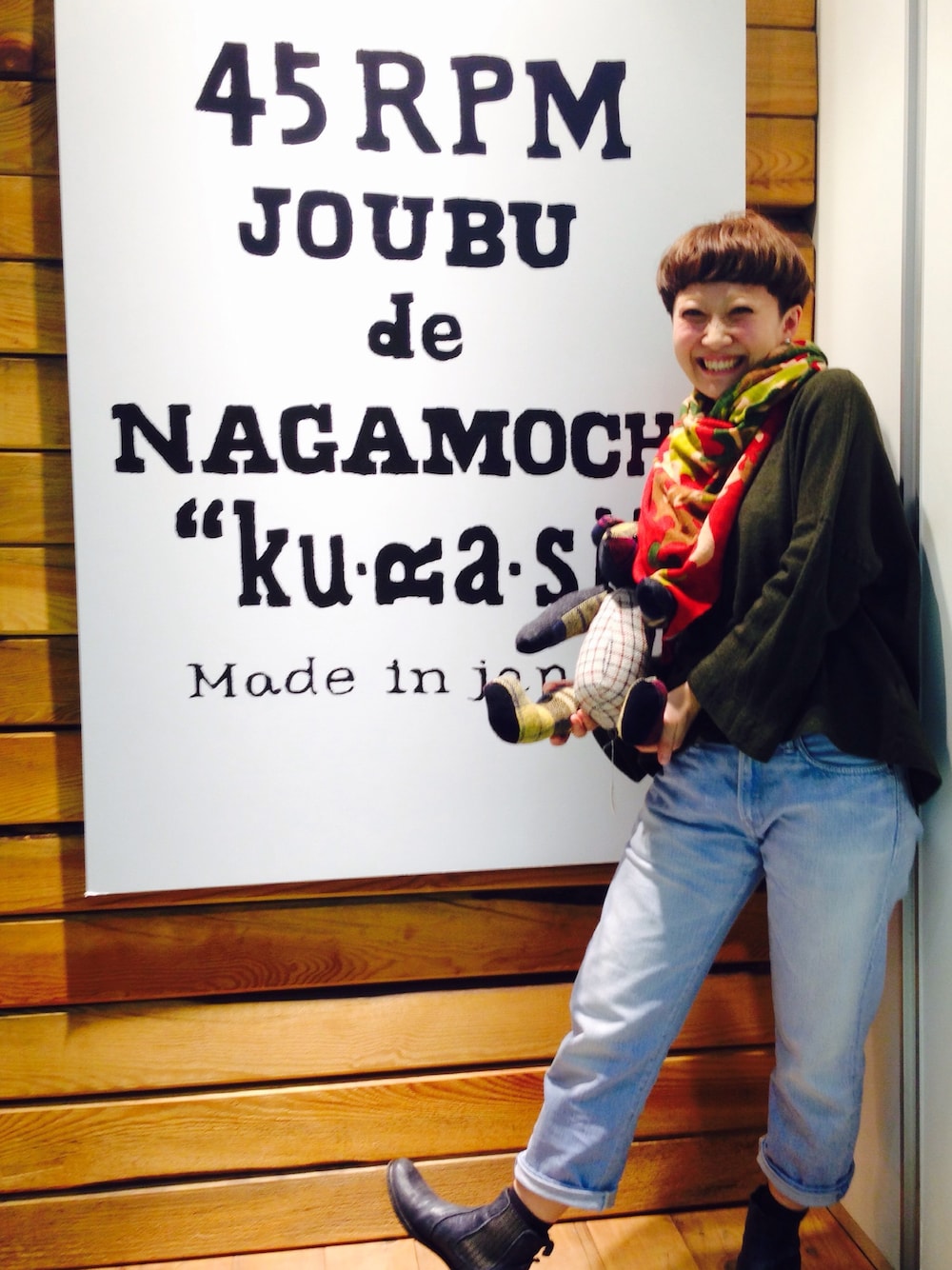 ブルー系のデニムパンツ、グリーン系のTシャツ/カットソー、レッド系のマフラーを着用したレディースの秋コーディネートの1枚目の写真