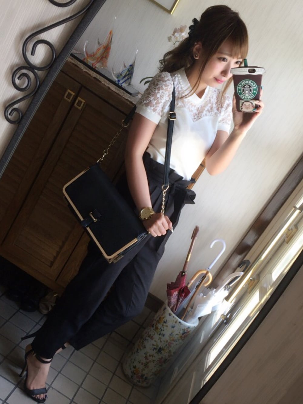 ホワイト系のトップス、ブラック系のバッグ、ブラック系のパンツを着用したレディースの夏コーディネートの1枚目の写真