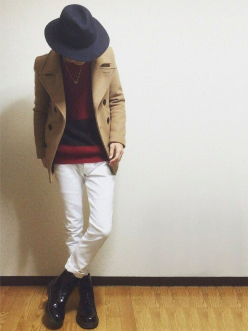 ブラウン系のピーコート、ブラック系のブーツ、ホワイト系のパンツを着用したメンズの冬コーディネートの1枚目の写真