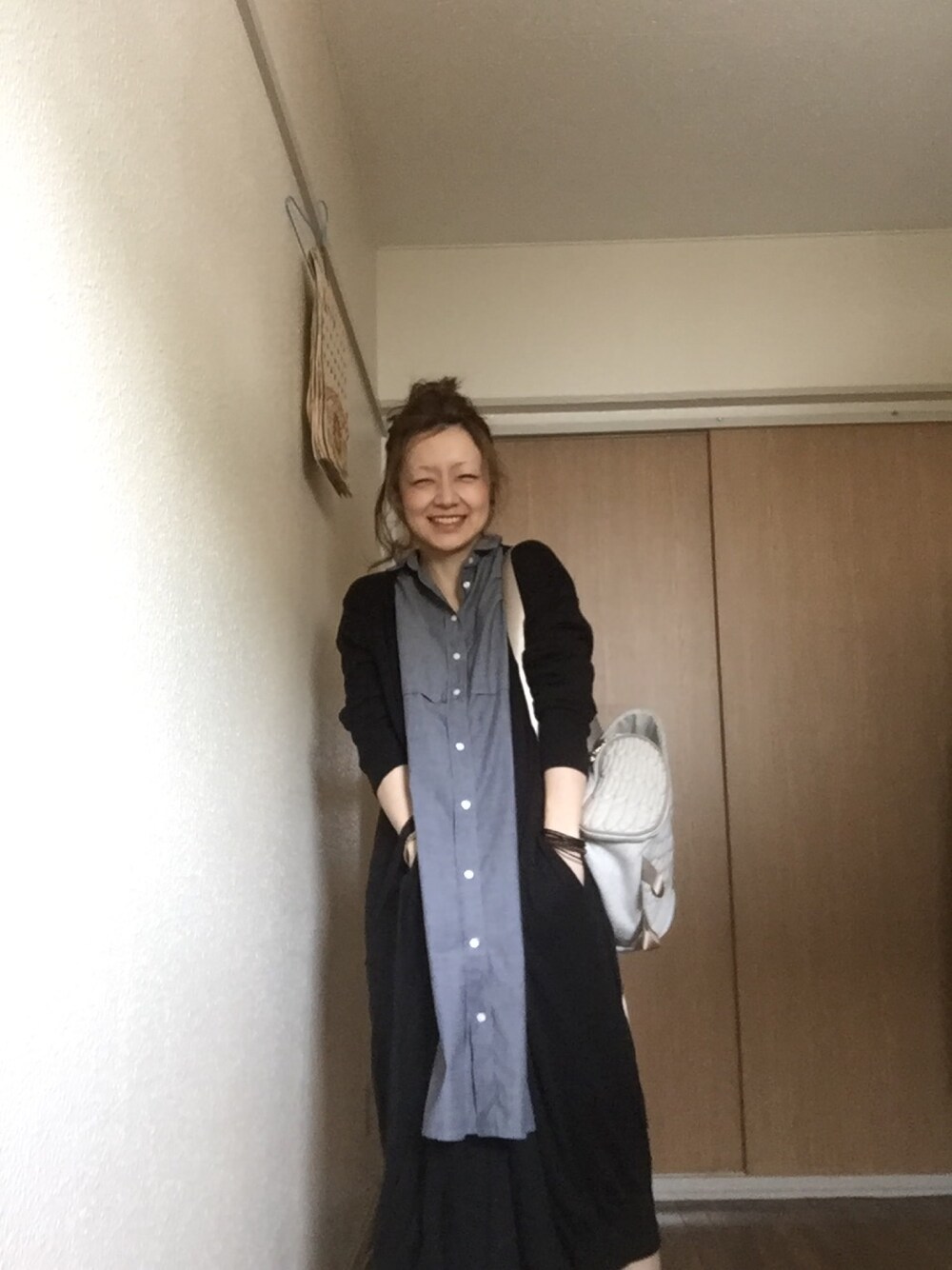 ブルー系のシャツワンピース、ブラック系のカーディガン/ボレロ、ブラック系のその他パンツを着用したレディースの春コーディネートの1枚目の写真