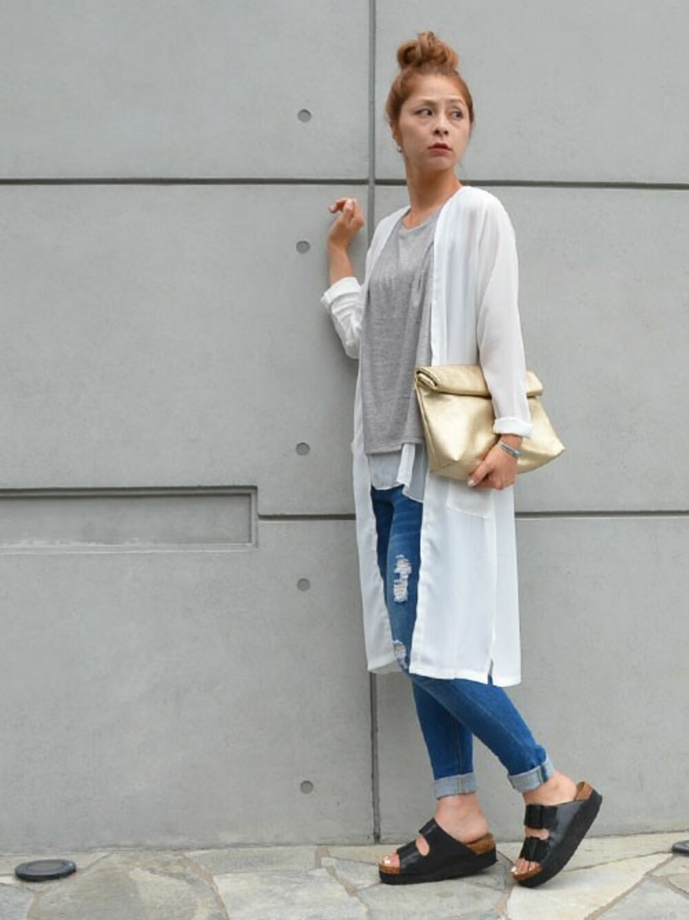 ゴールド系のクラッチバッグ、ブルー系のデニムパンツ、グレー系のタンクトップを着用したレディースの夏コーディネートの1枚目の写真