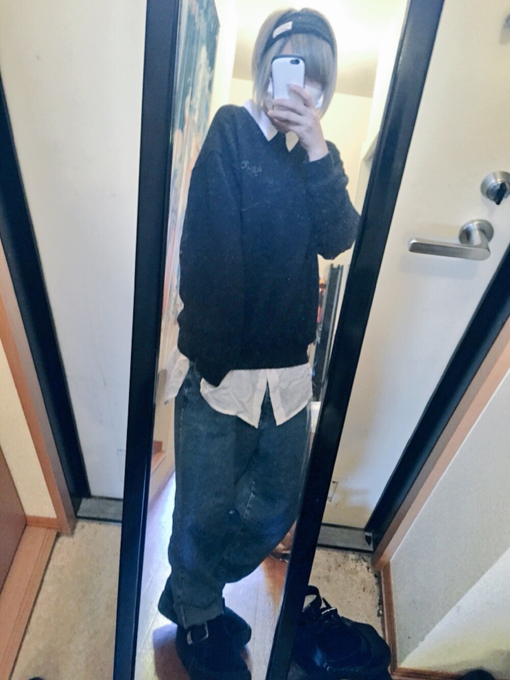 ブラック系のスウェット、ブルー系のデニムパンツ、ブラック系のスニーカーを着用したレディースの春コーディネートの1枚目の写真