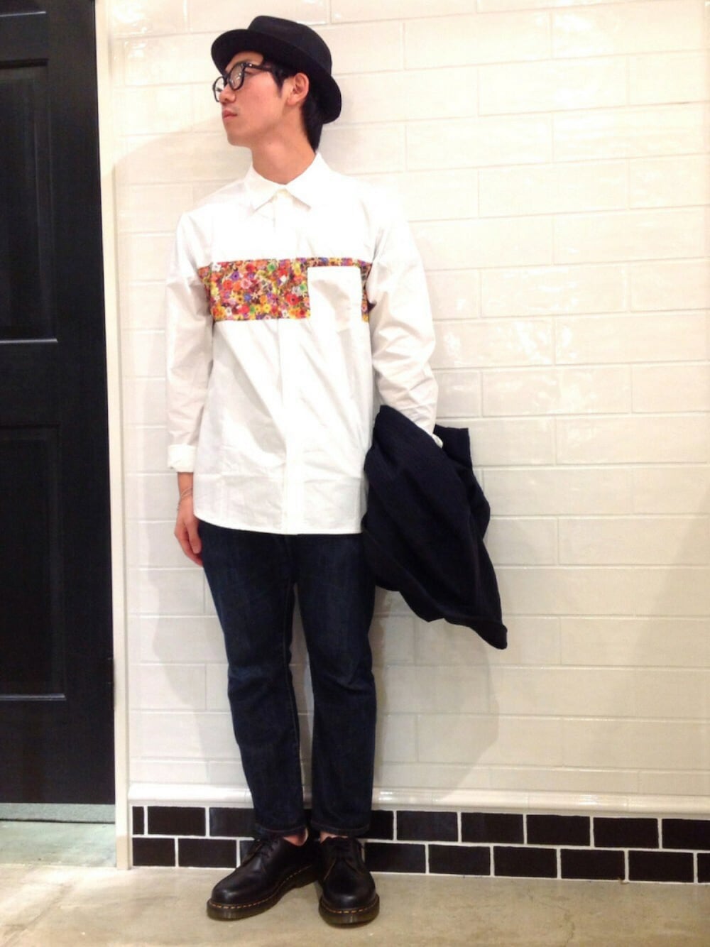 グレー系のTシャツ/カットソー、ブルー系のデニムパンツ、ブラック系のシューズを着用したメンズの秋コーディネートの1枚目の写真