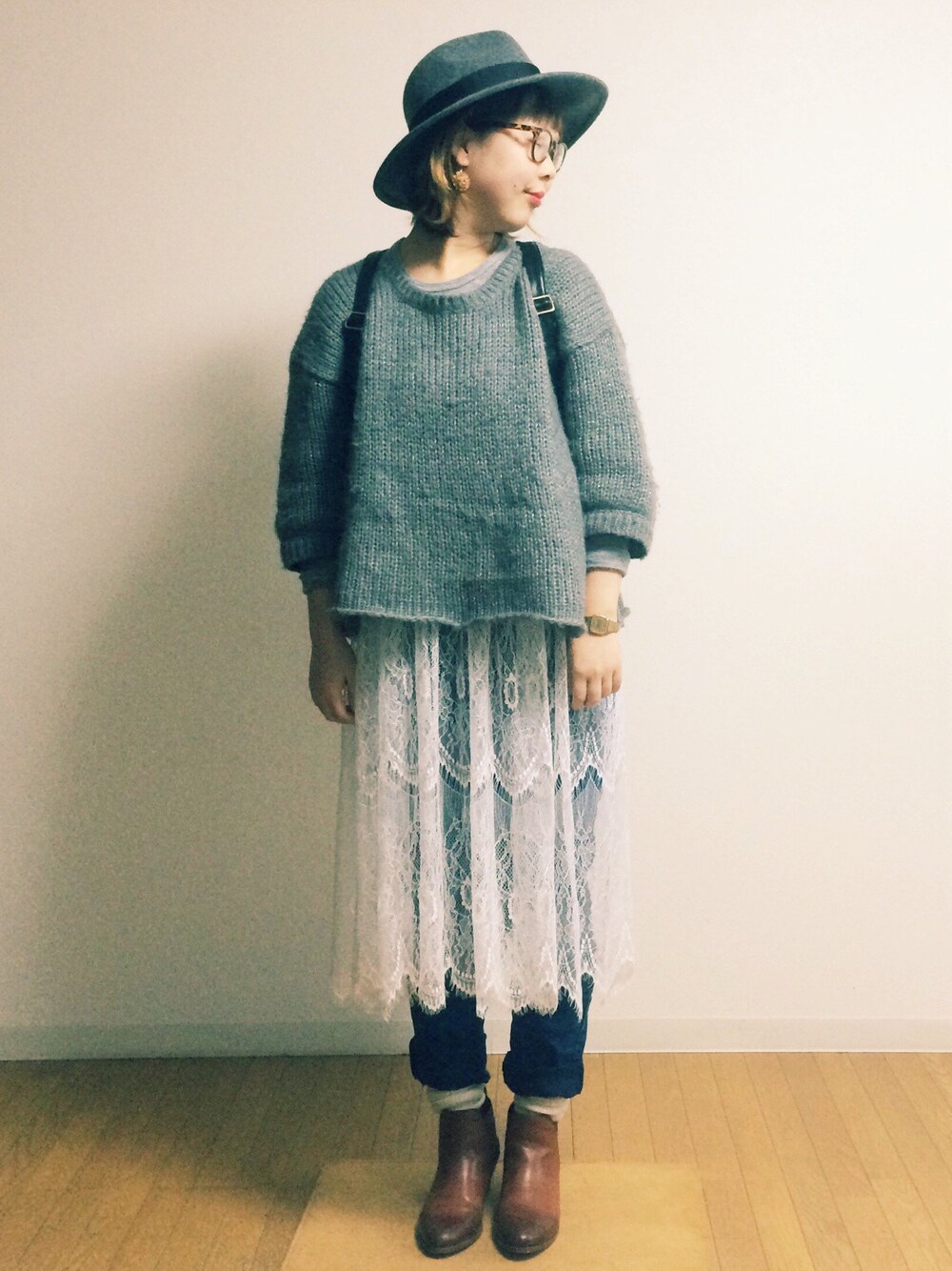 グレー系のニット/セーター、ホワイト系のスカート、ブラウン系のブーツを着用したレディースの秋コーディネートの1枚目の写真