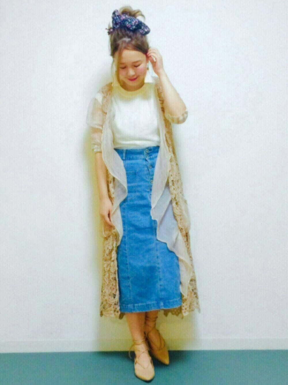 ホワイト系のベスト、ブルー系のデニムスカート、ベージュ系のシューズを着用したレディースの春コーディネートの1枚目の写真