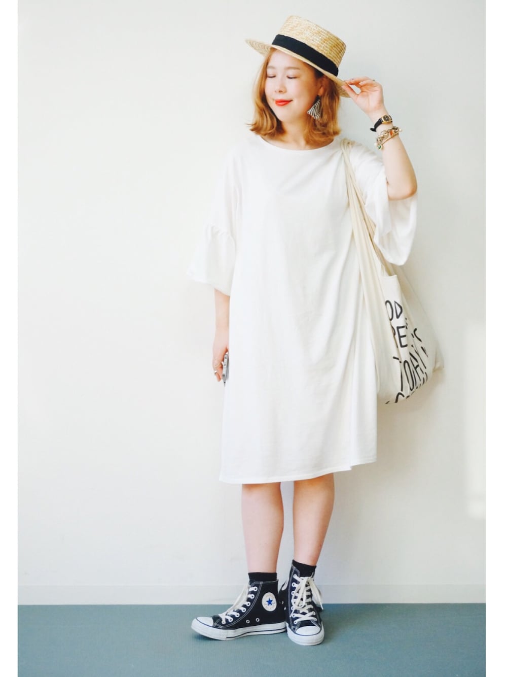 ブラック系のスニーカー、ホワイト系のエコバッグ/サブバッグ、ホワイト系のワンピースを着用したレディースの夏コーディネートの1枚目の写真