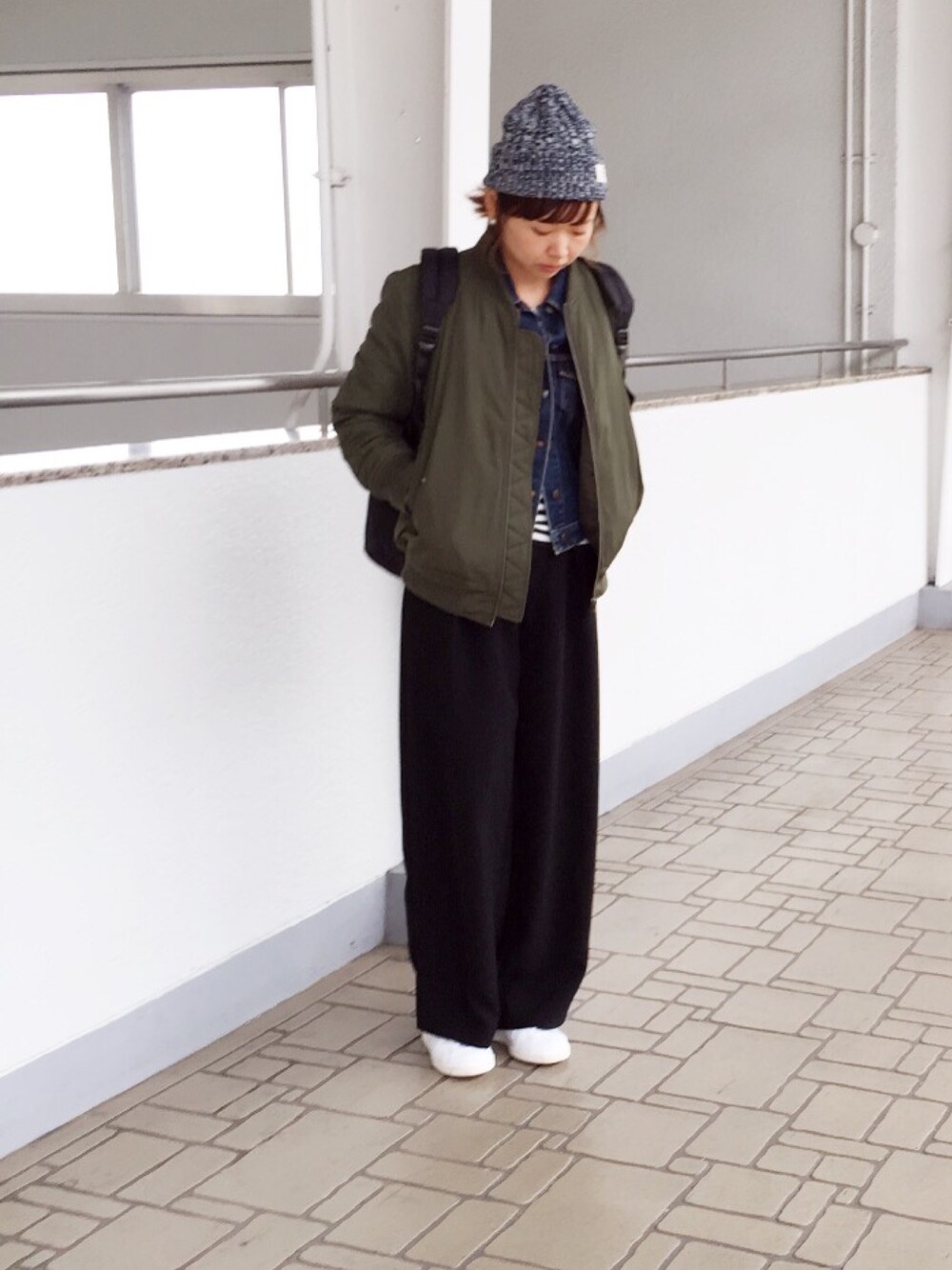 グリーン系のブルゾン、ブラック系のその他パンツ、ホワイト系のスニーカーを着用したレディースの冬コーディネートの1枚目の写真