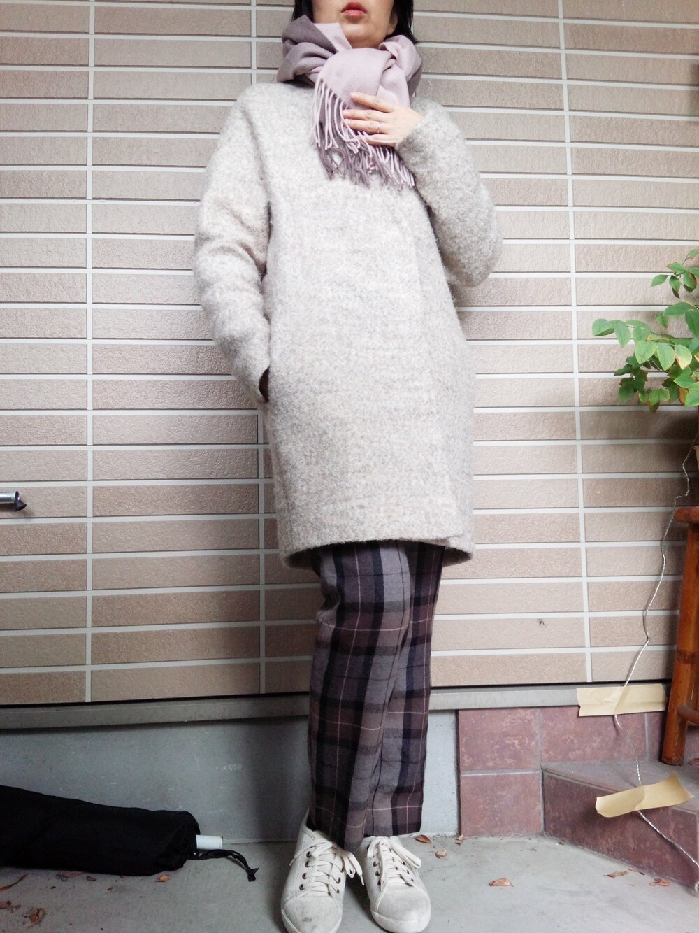 ベージュ系のステンカラーコート、ピンク系のマフラーを着用したレディースの冬コーディネートの1枚目の写真