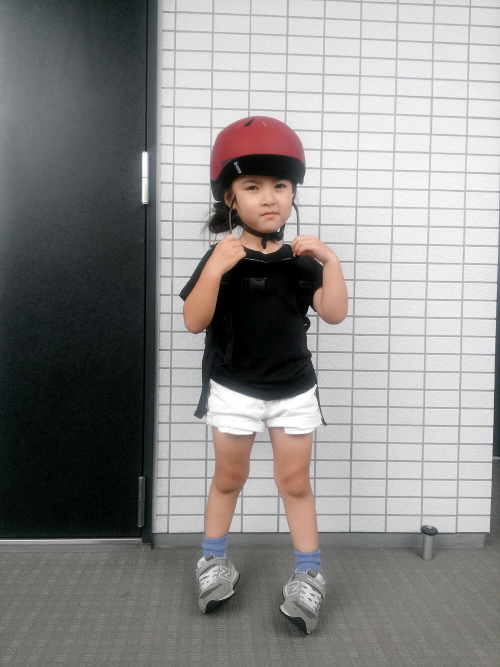 ブラック系のトップス、ホワイト系のパンツ、グレー系のスニーカーを着用したキッズの夏コーディネートの1枚目の写真