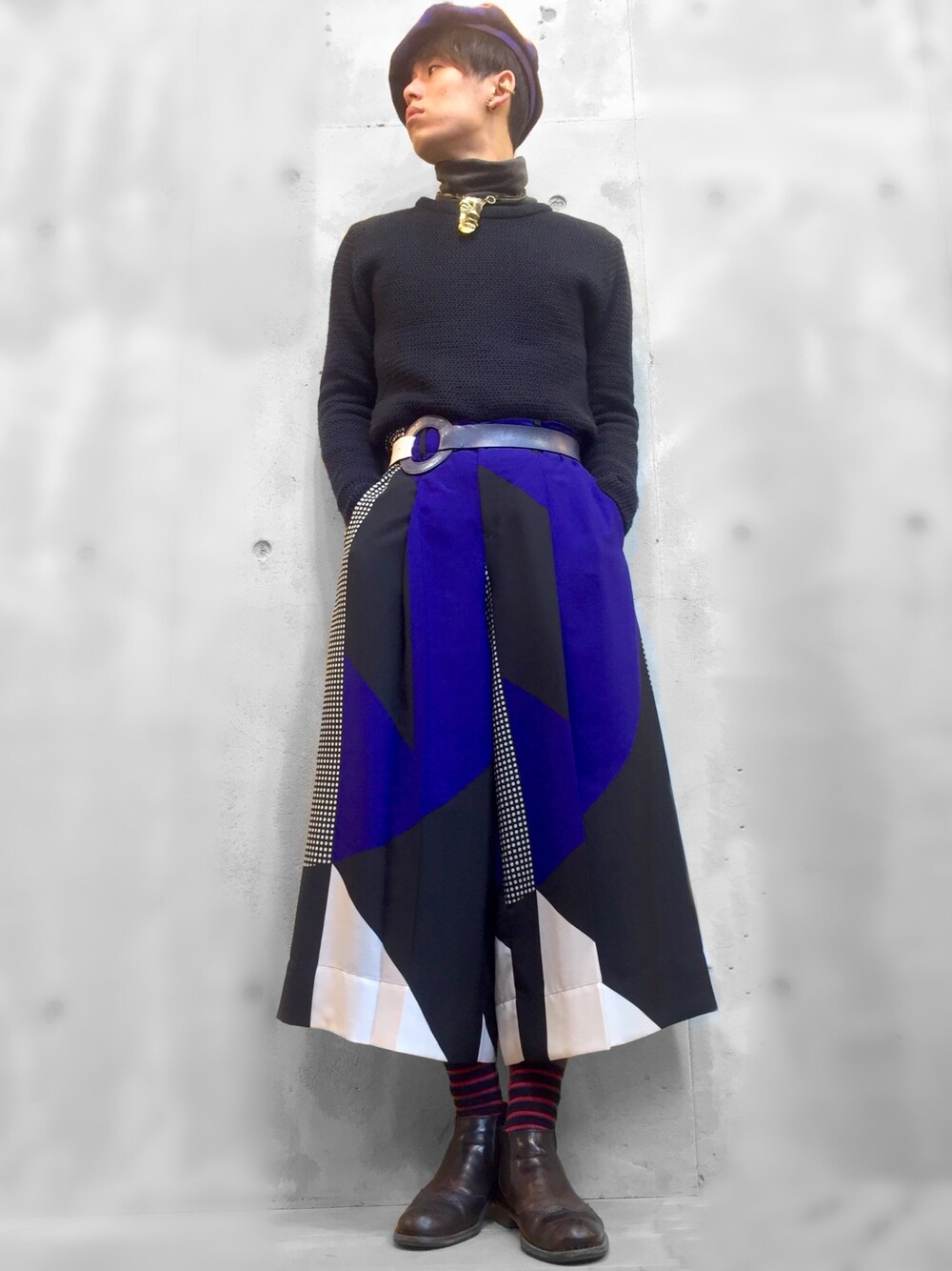 ブラック系のニット/セーター、ブルー系のパンツ、ブラック系のブーツを着用したメンズの冬コーディネートの1枚目の写真