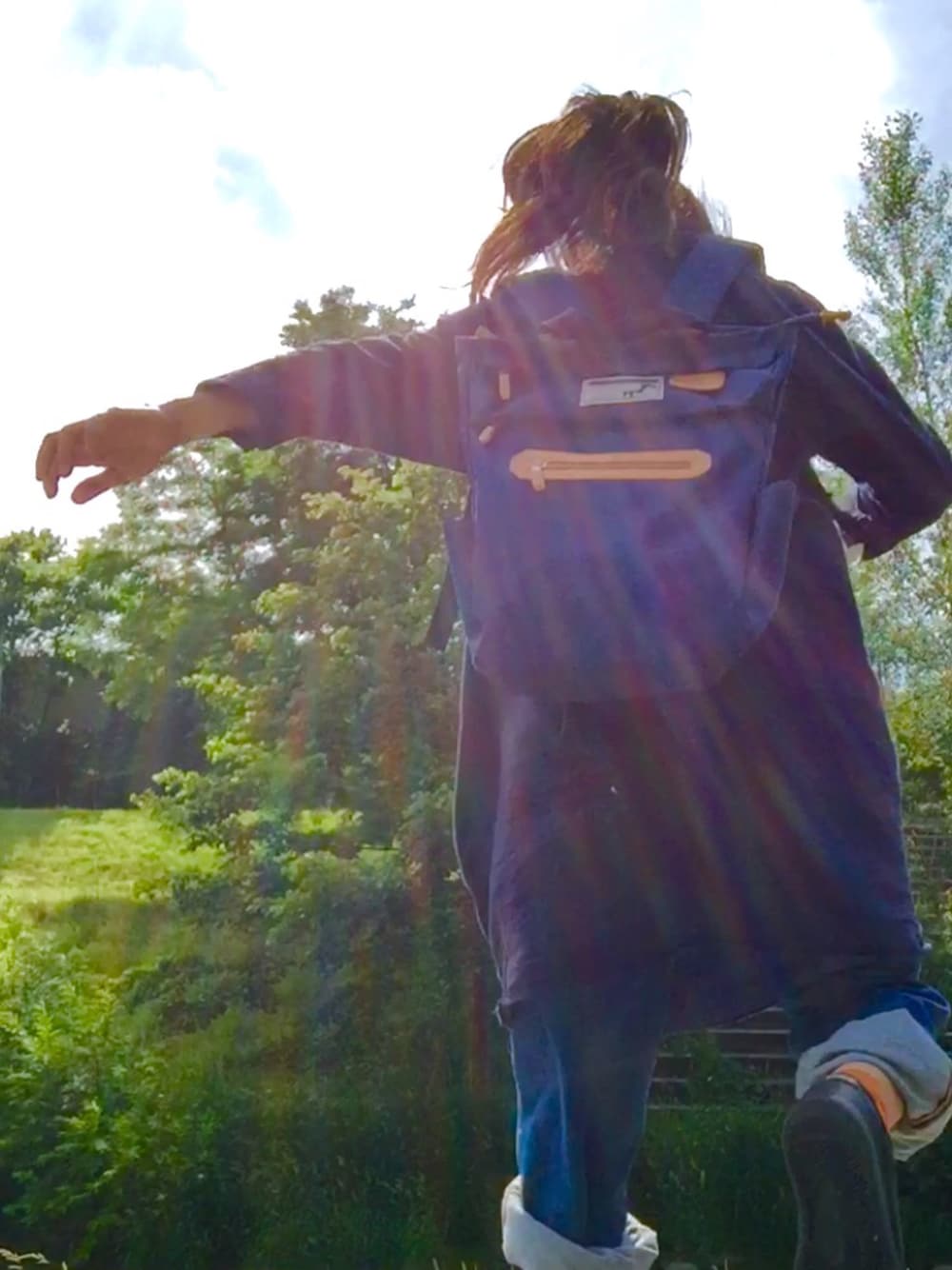 ブルー系のワンピース、ブラック系のバックパック/リュック、ブラック系のスニーカーを着用したレディースの夏コーディネートの1枚目の写真