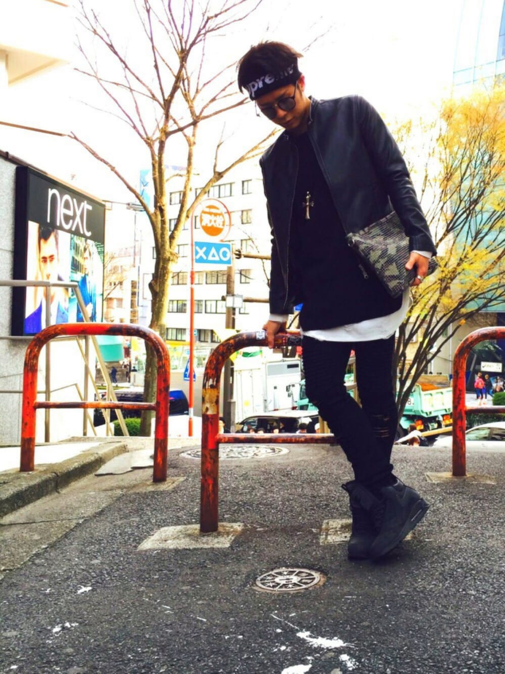 ブラック系のライダースジャケット、ホワイト系のTシャツ/カットソー、ホワイト系のクラッチバッグを着用したメンズの春コーディネートの1枚目の写真