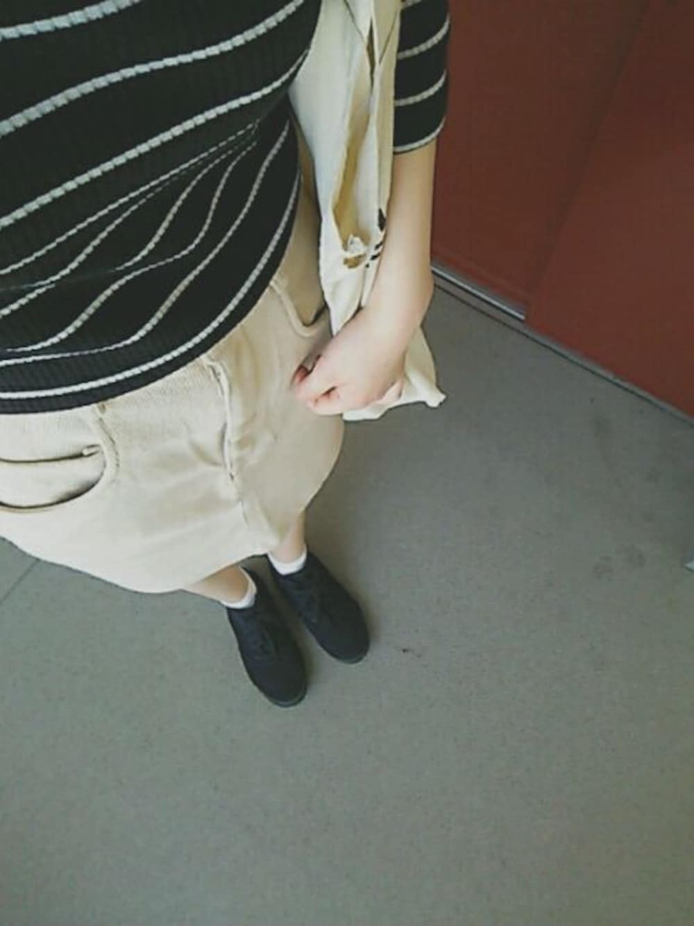 ブラック系のTシャツ/カットソー、ベージュ系のスカート、ブラック系のスニーカーを着用したレディースの夏コーディネートの1枚目の写真