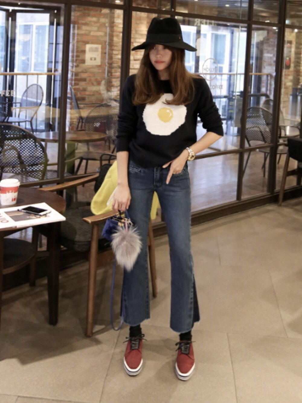 ブラック系のニット/セーター、ブルー系のデニムパンツ、レッド系のスニーカーを着用したレディースの秋コーディネートの1枚目の写真