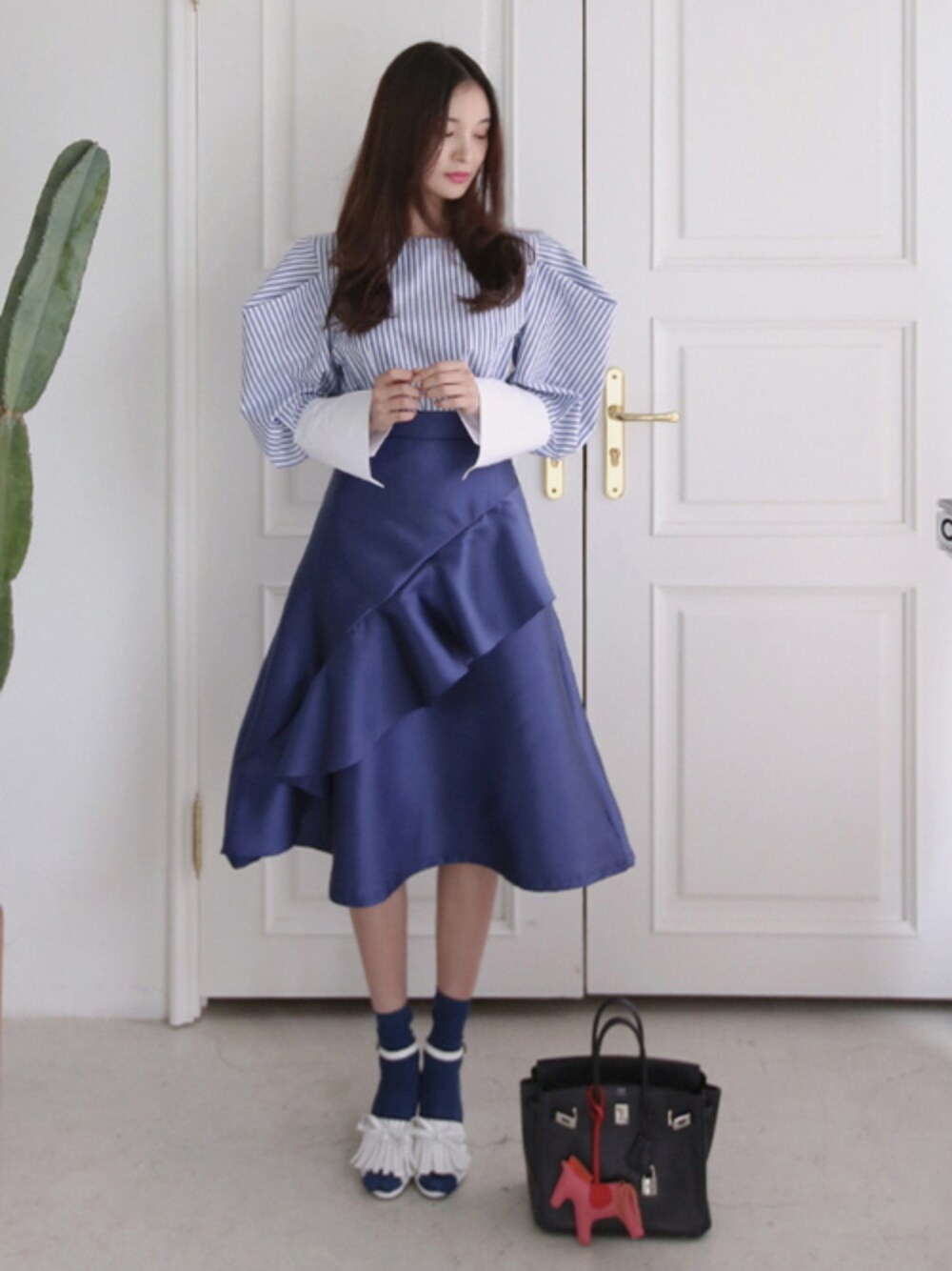 ブルー系のシャツ/ブラウス、ブルー系のスカート、ホワイト系のサンダルを着用したレディースの冬コーディネートの1枚目の写真