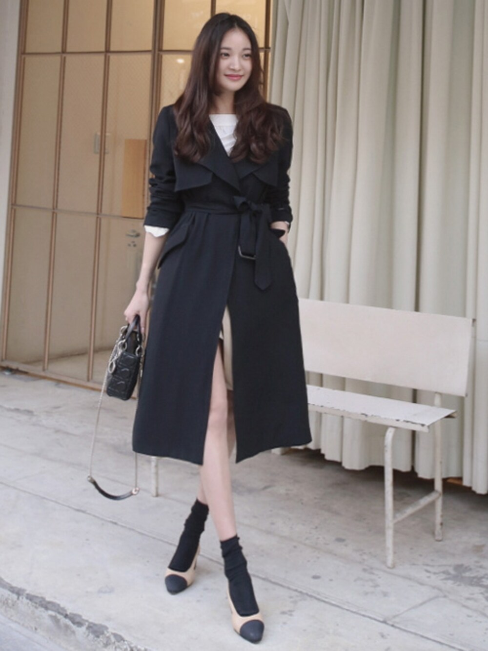 ブラック系のトレンチコートを着用したレディースの春コーディネートの1枚目の写真