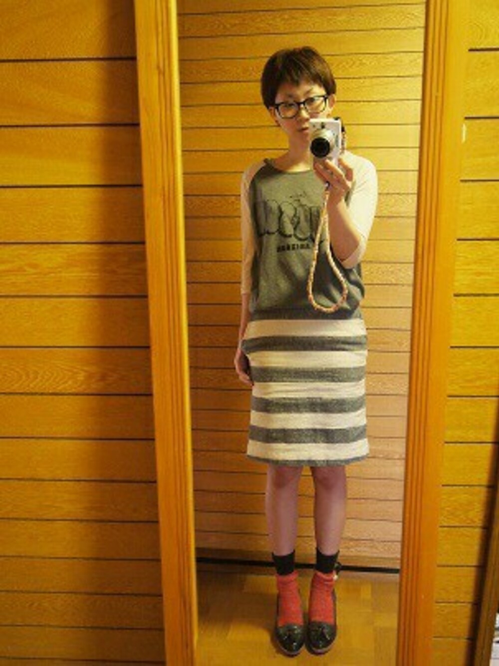 グレー系のTシャツ/カットソー、ブルー系のスカート、グレー系のパンプスを着用したレディースの春コーディネートの1枚目の写真