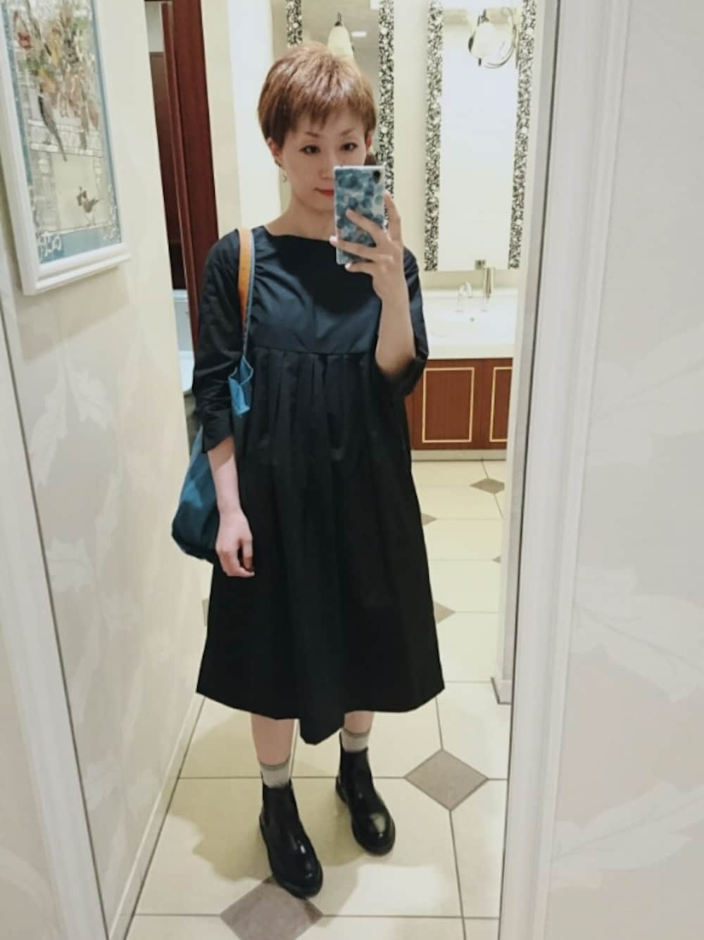 ブラック系のワンピース、ブラック系のブーツを着用したレディースの秋コーディネートの1枚目の写真