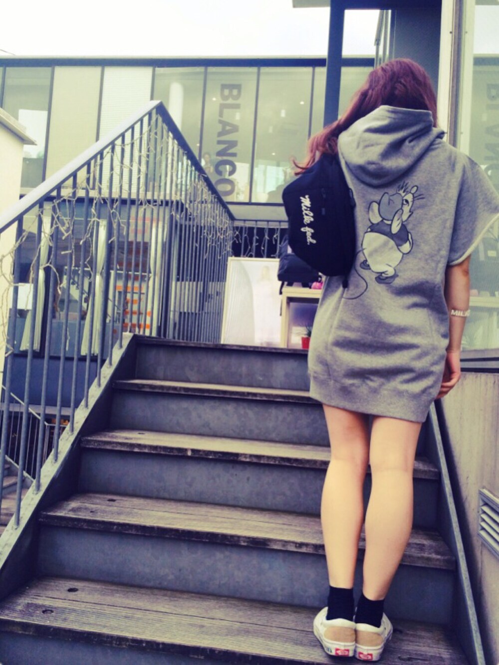 グレー系のスウェット、ブラック系のボディバッグ/ウエストポーチ、ホワイト系のスニーカーを着用したレディースの夏コーディネートの1枚目の写真