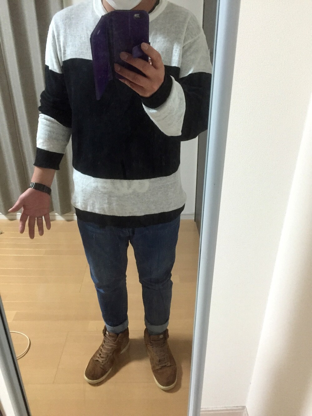 ブラック系のニット/セーター、ブルー系のデニムパンツ、ブラウン系のスニーカーを着用したメンズの春コーディネートの1枚目の写真