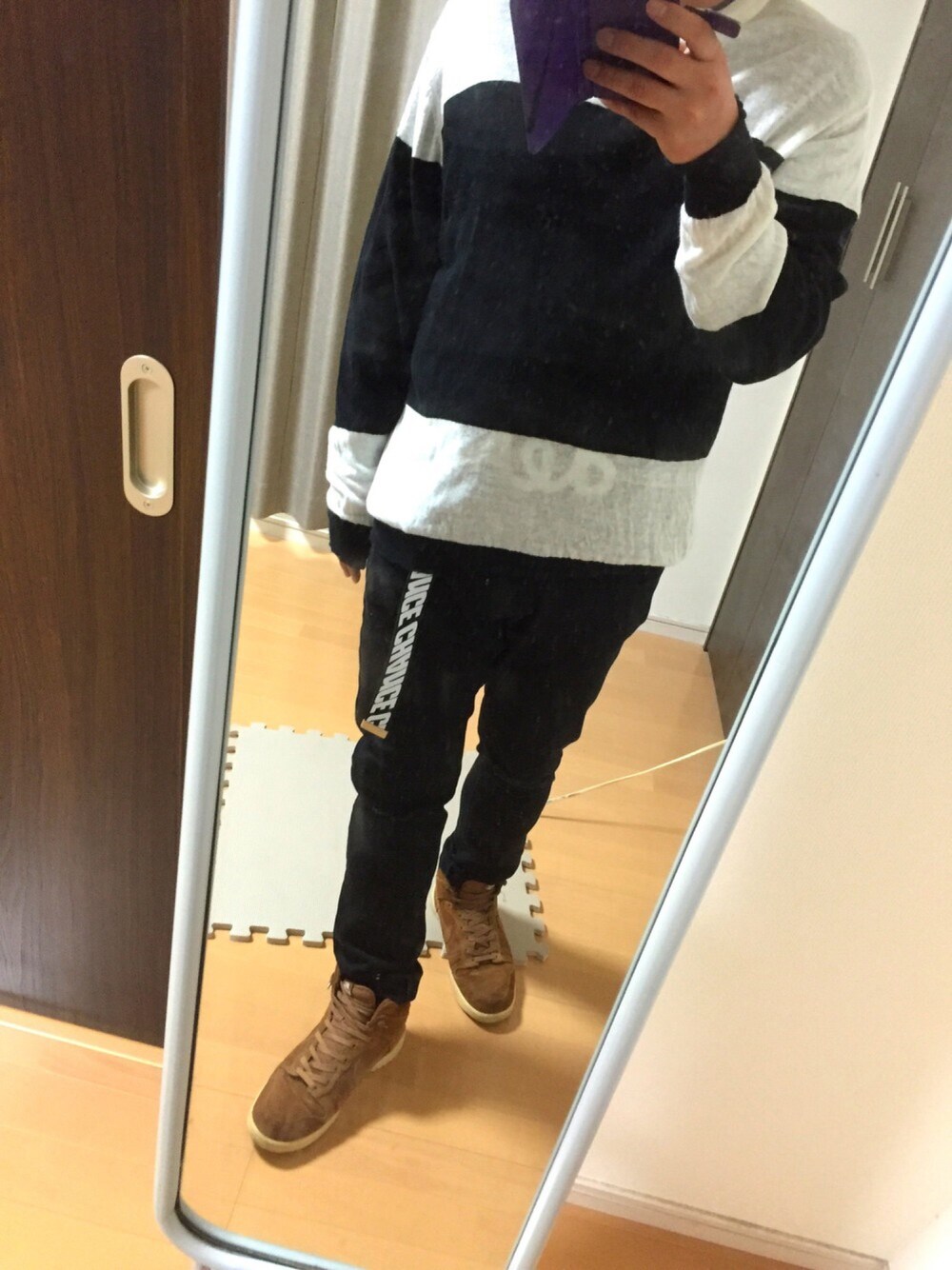 ブラック系のニット/セーター、ブラック系のデニムパンツ、ブラウン系のスニーカーを着用したメンズの秋コーディネートの1枚目の写真